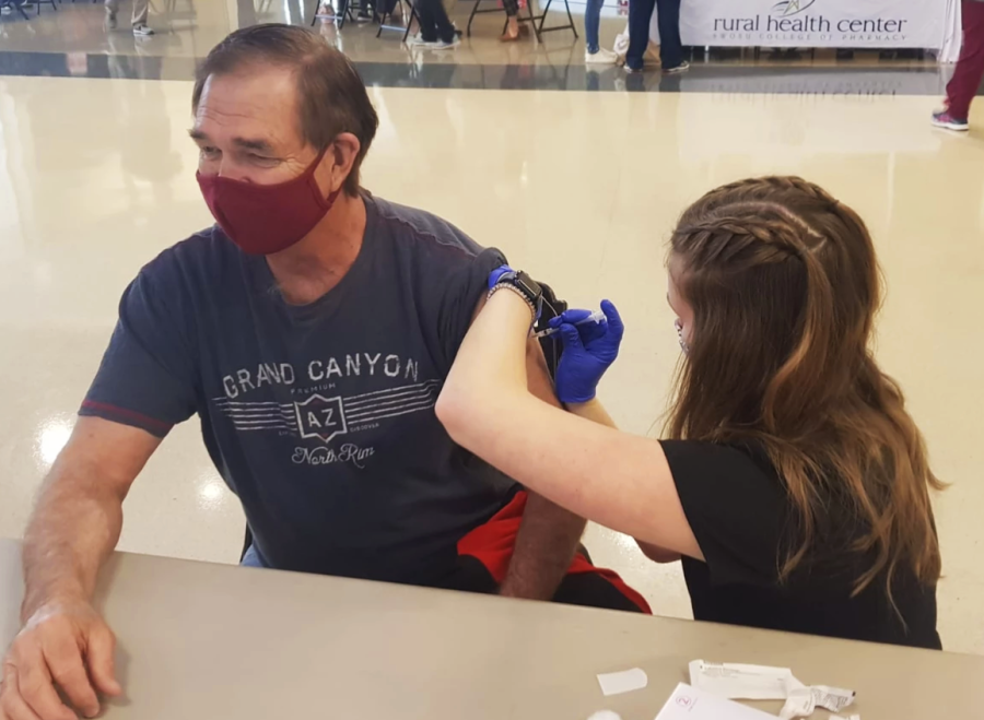 SWOSU pharmacy student Brianne Kirchgessner is giving a COVID-19 shot. Around 300 people received a vaccine on Friday in the Pioneer Cellular Event Center.